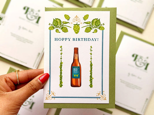 Beer Birthday card reading "hoppy birthday" and a bottle of beer with hops around it