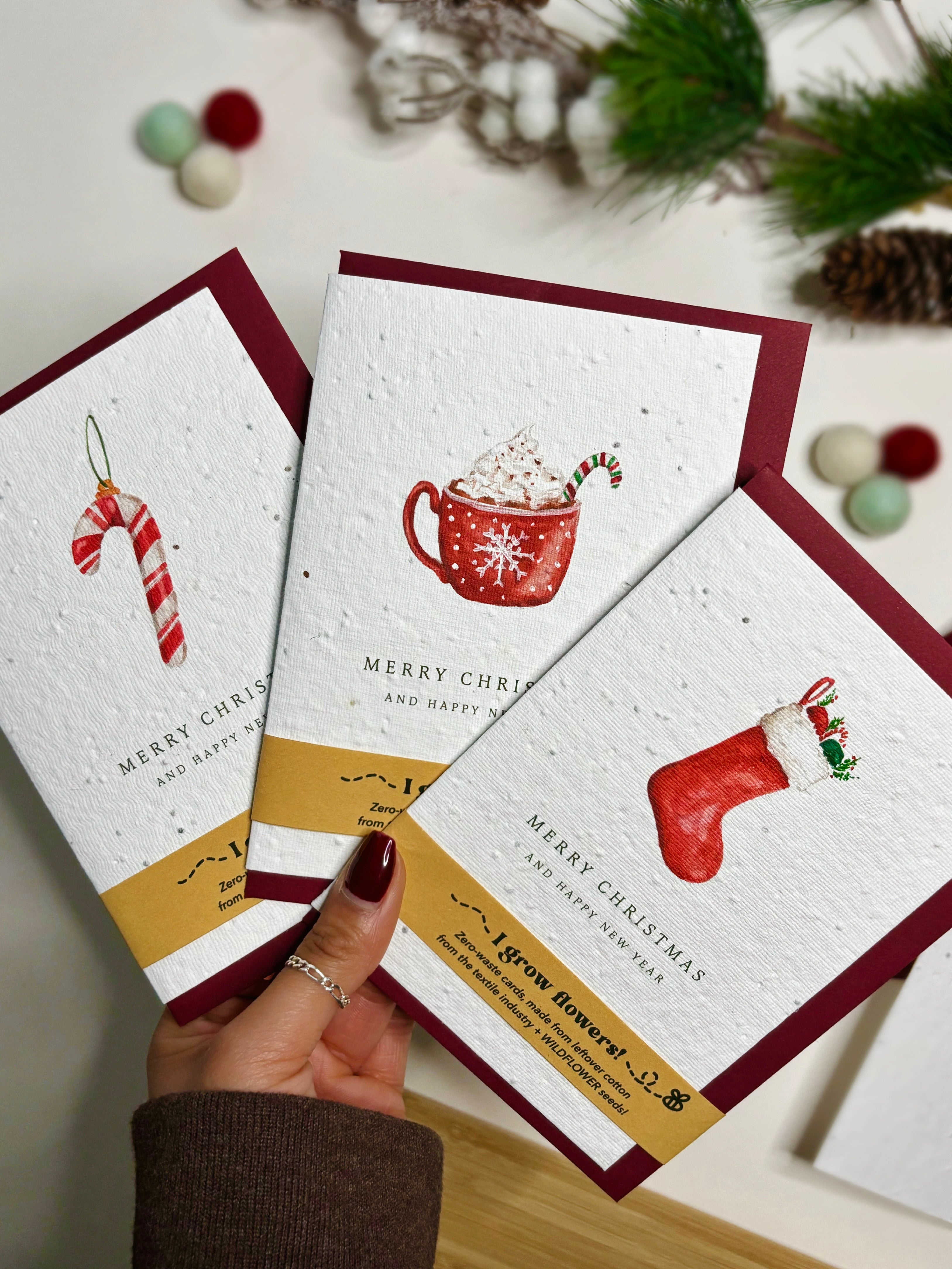 Plantable Christmas Cards containing wildflower seeds, each card has a traditional Christmassy watercolour painting on; a candy cane, a hot chocolate with all of the toppings, and a stocking filled to overflow with goodies!