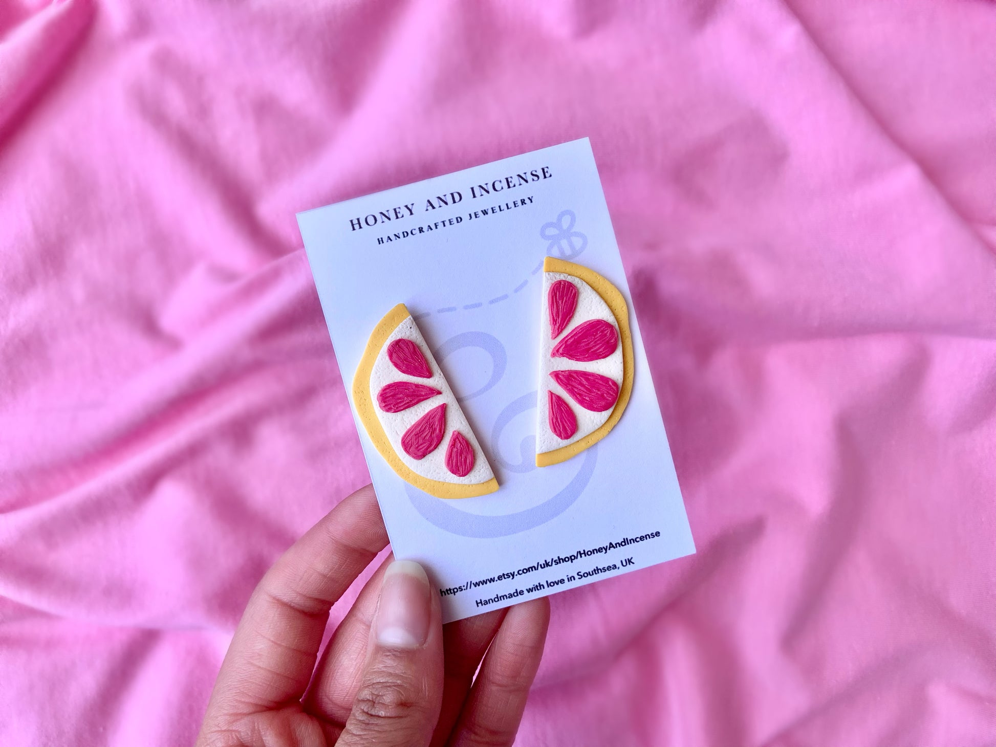 Pink grapefruit slice earrings, each earring is a slice which when put together makes a whole round slice. yellow edge with hot pink segemnts