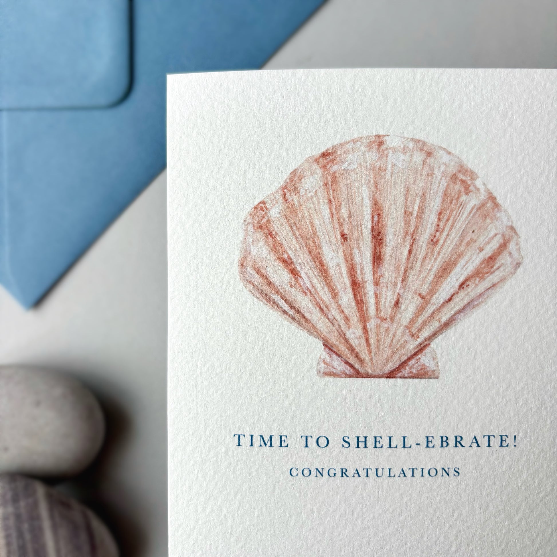 Greeting card with a shell design and text 'Time to shell-ebrate! Congratulations' on a white background.