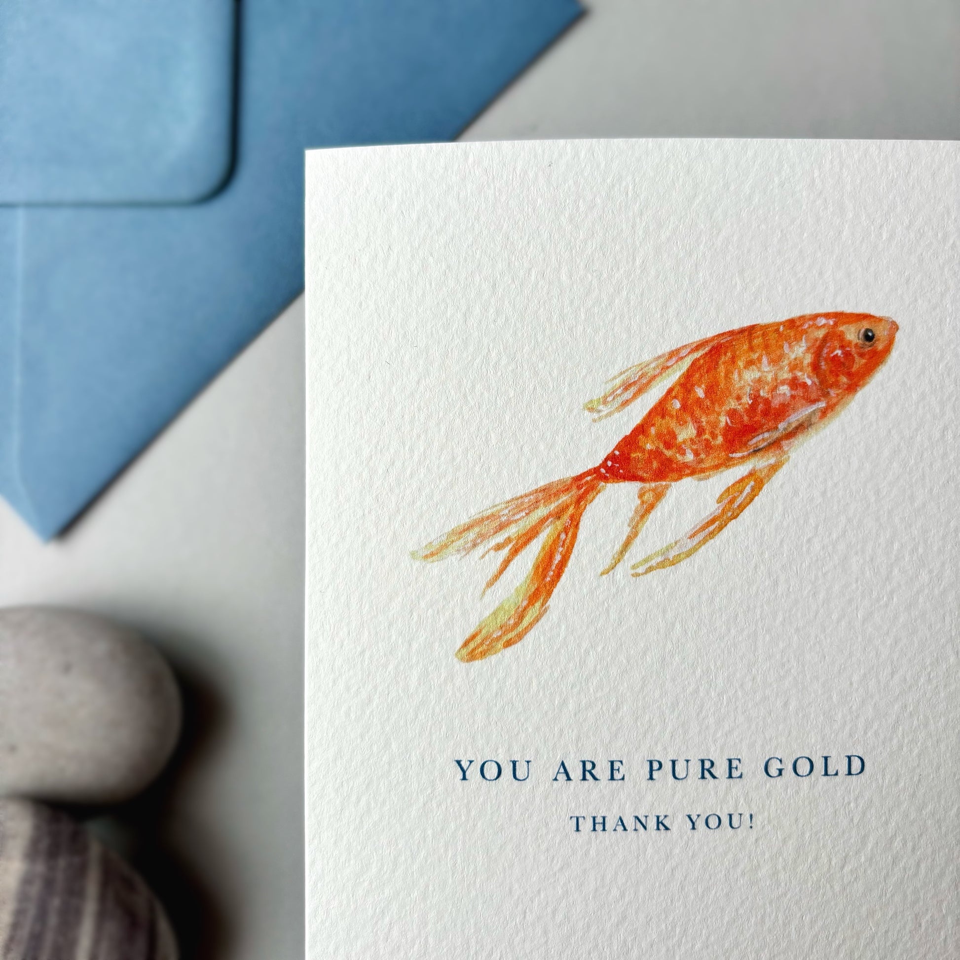Card with a goldfish illustration and text 'You are pure gold, thank you!' next to a blue envelope.