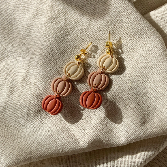 polymer clay pumpkins in the colours ivory, dusky pink and terracotta joined together in a dangling earring